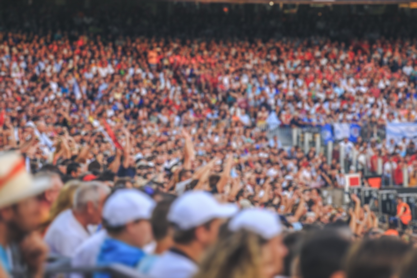 Blurred crowd of spectators packed into a stadium at a live sporting event