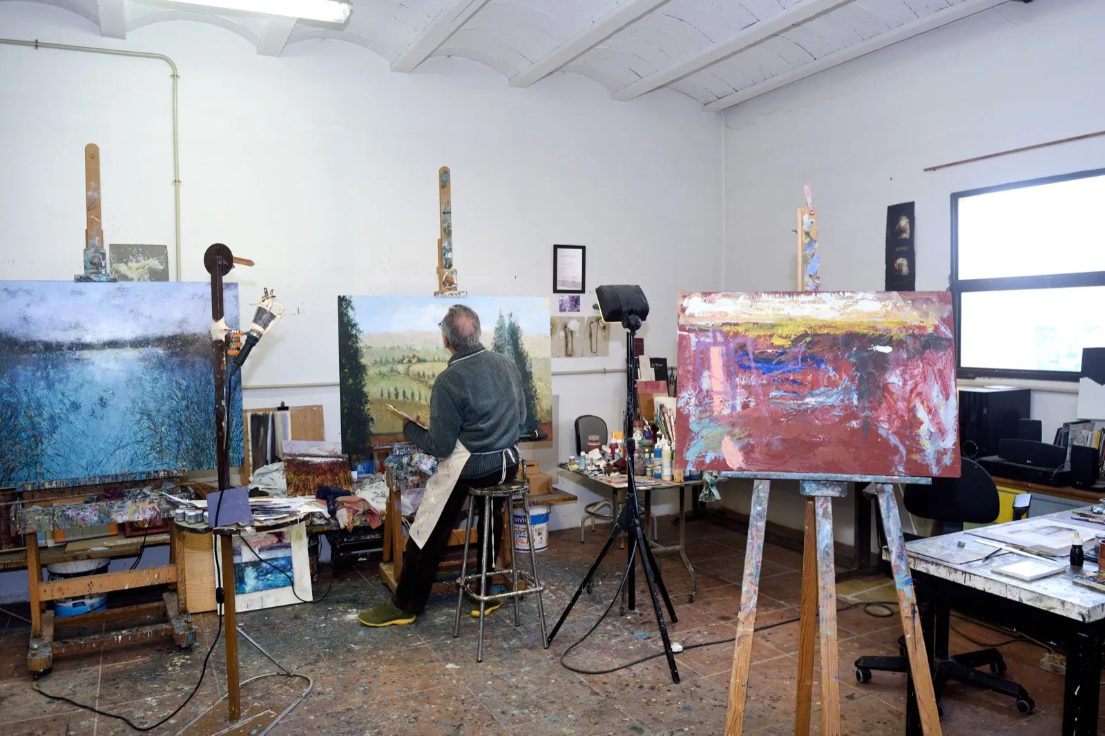 Artist painting a canvas by hand in a studio, human craft beyond automation