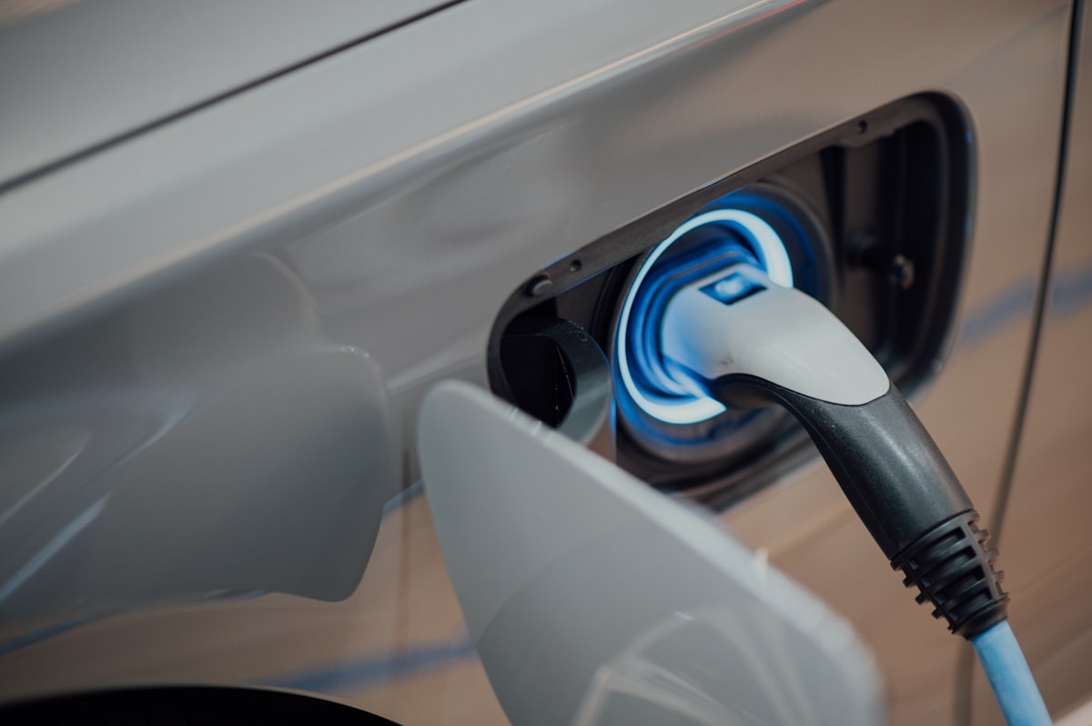 Close-up of an electric vehicle charging cable plugged into a car