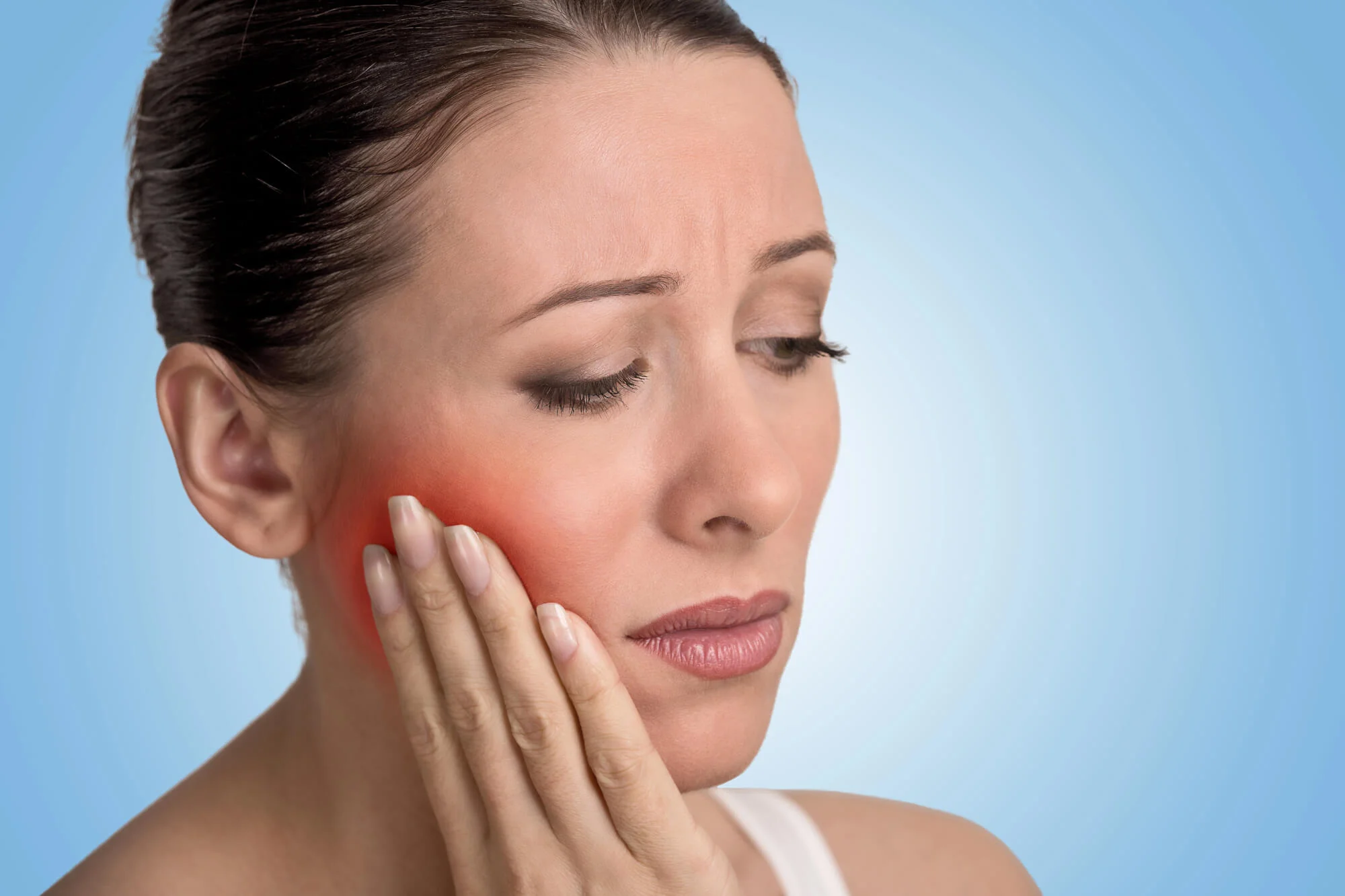 Woman holding cheek in pain dental emergency in Hueytown