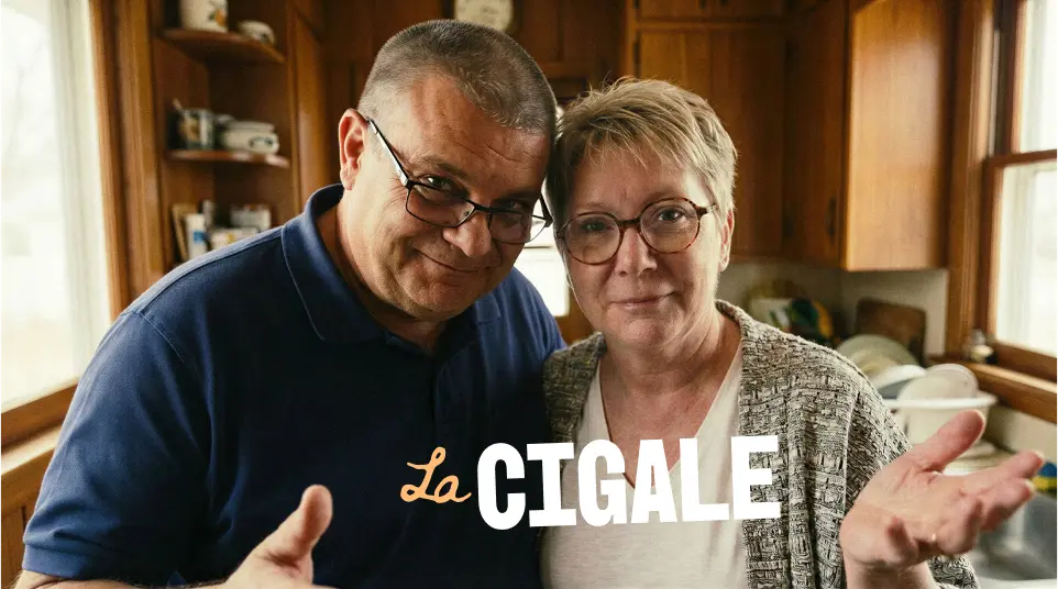 Un homme et une femme portant des lunettes sourient dans une cuisine en bois avec le texte La Cigale.