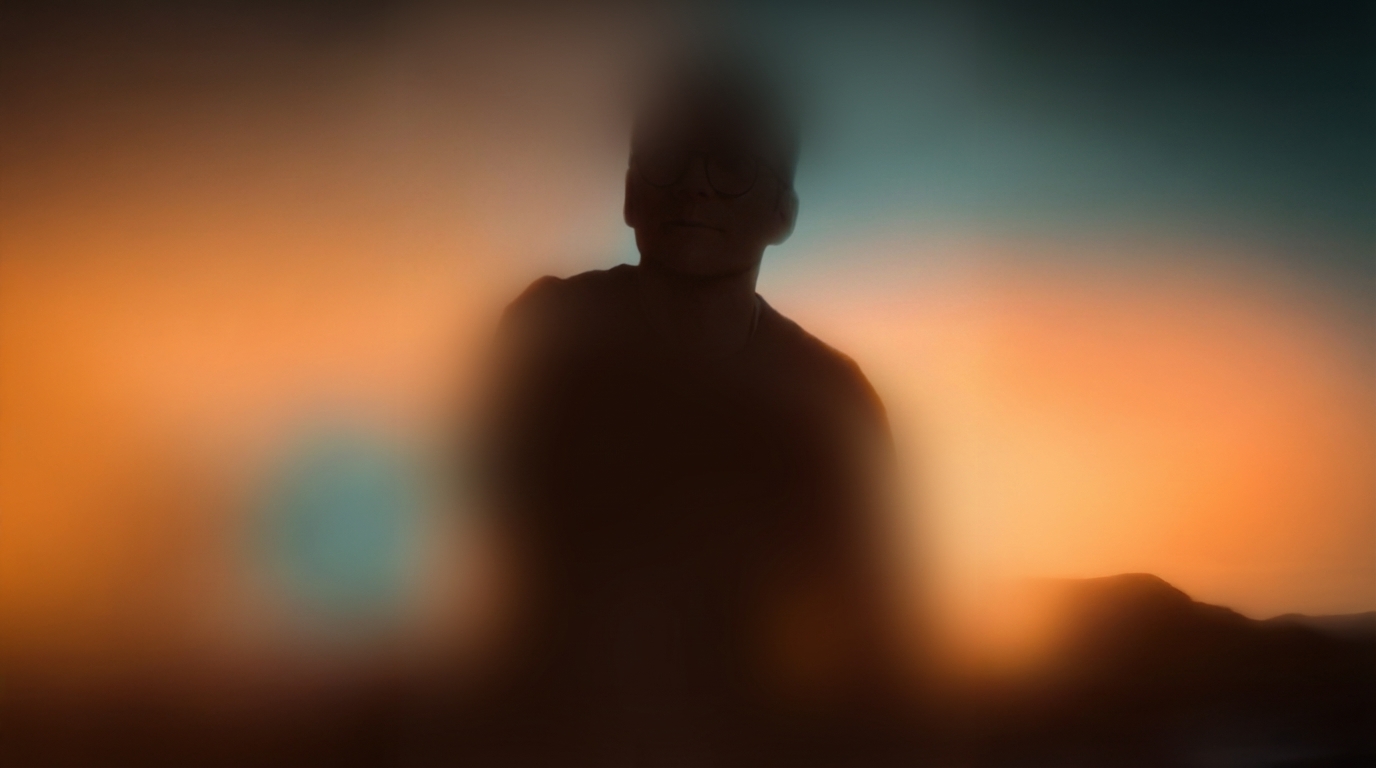 Blurred silhouette of a person against a glowing orange and blue sunset sky