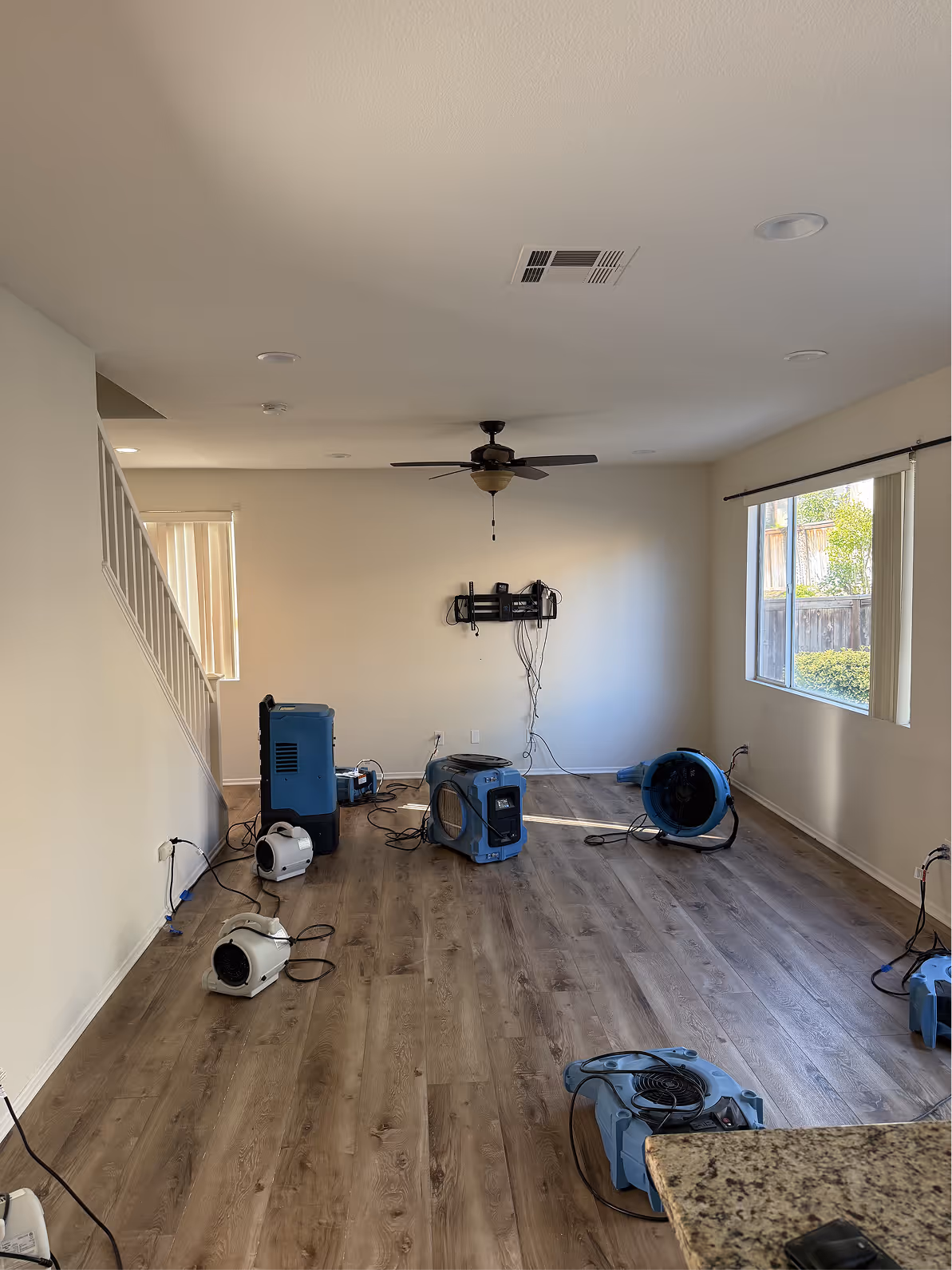 Dehumidifier and air movers drying a living room
