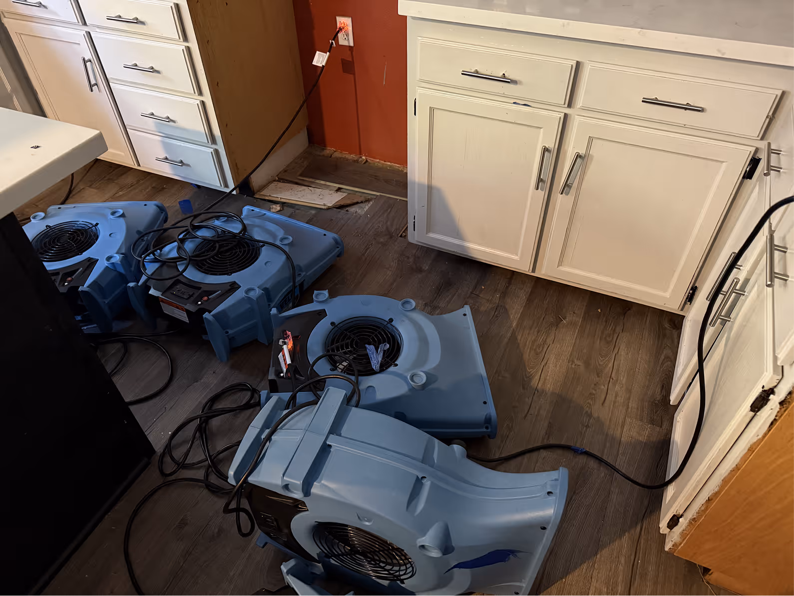 Air movers drying a kitchen floor