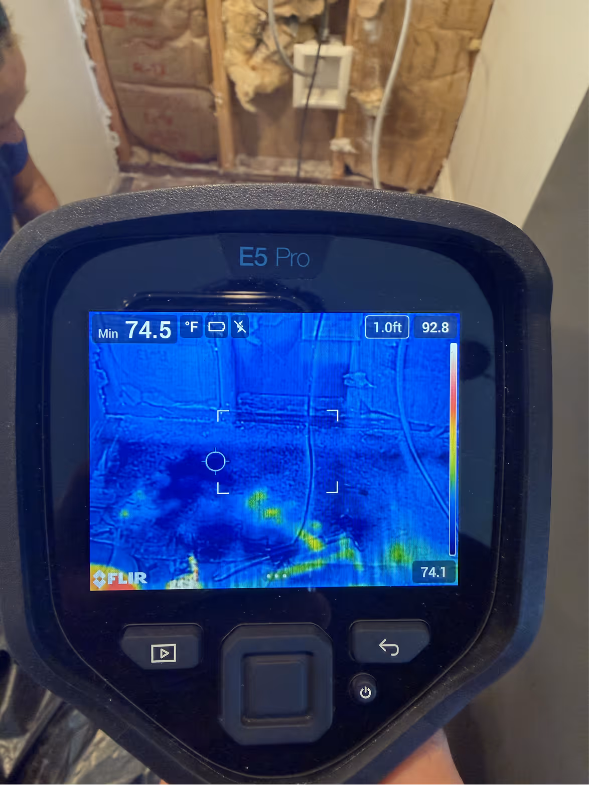 Thermal camera screen showing hidden moisture in a wall