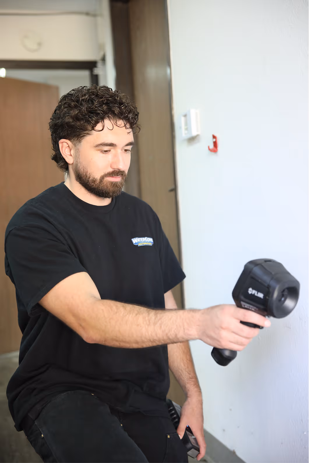Technician scanning a wall with a thermal camera