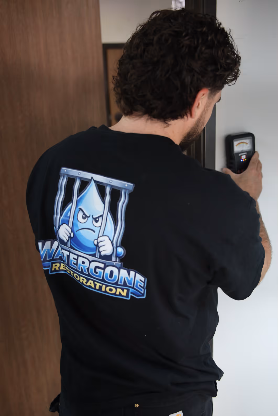 Water Gone Restoration technician checking a wall with a moisture meter
