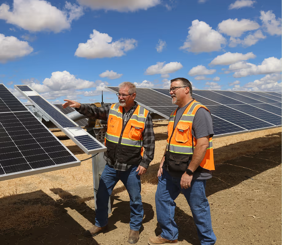 Employees in front of solar panels on site at Permanent Power Company in San Joaquin Valley, California
