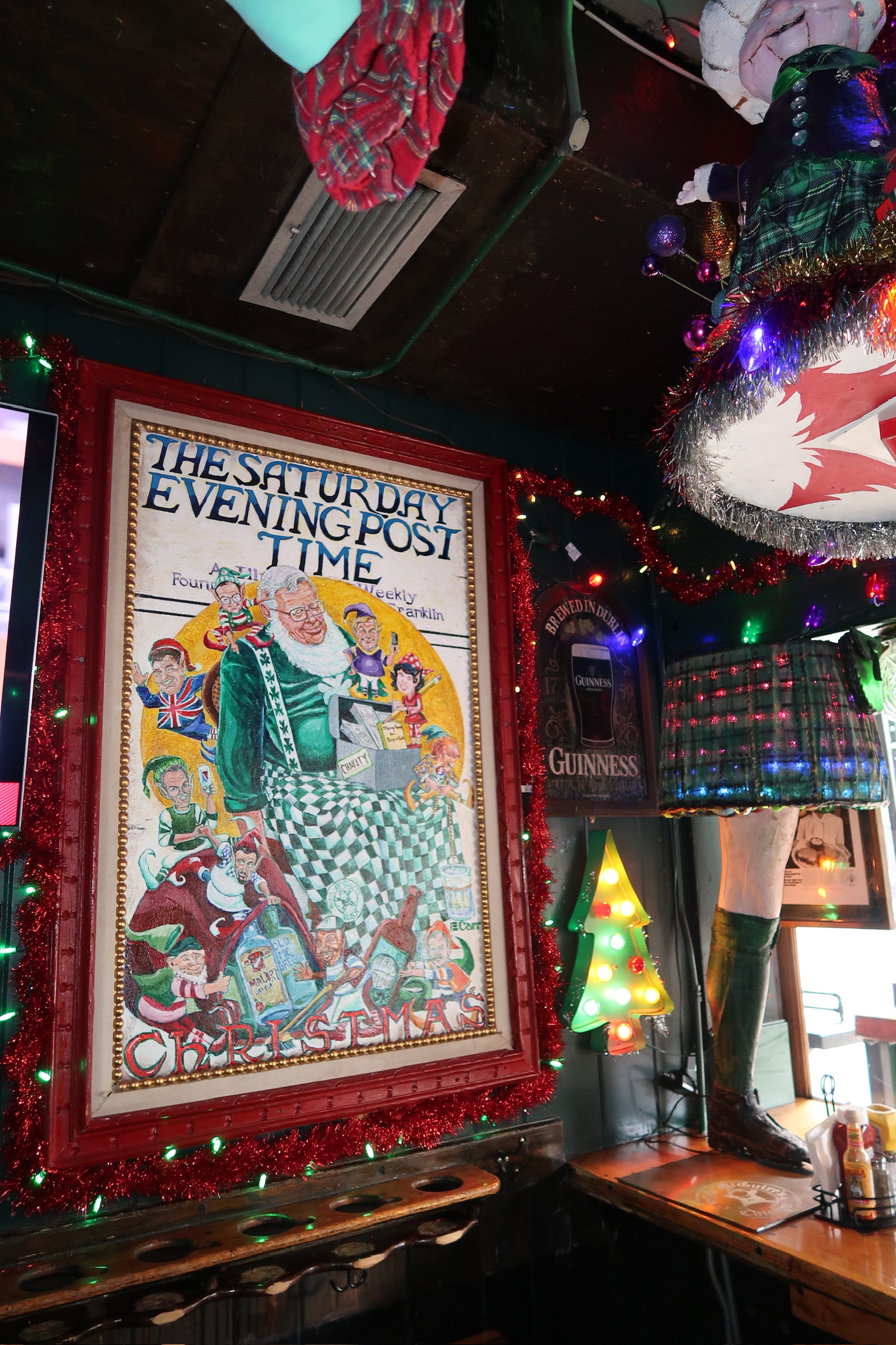 A framed Saturday Evening Post Christmas cover on the wall at Butch McGuire's