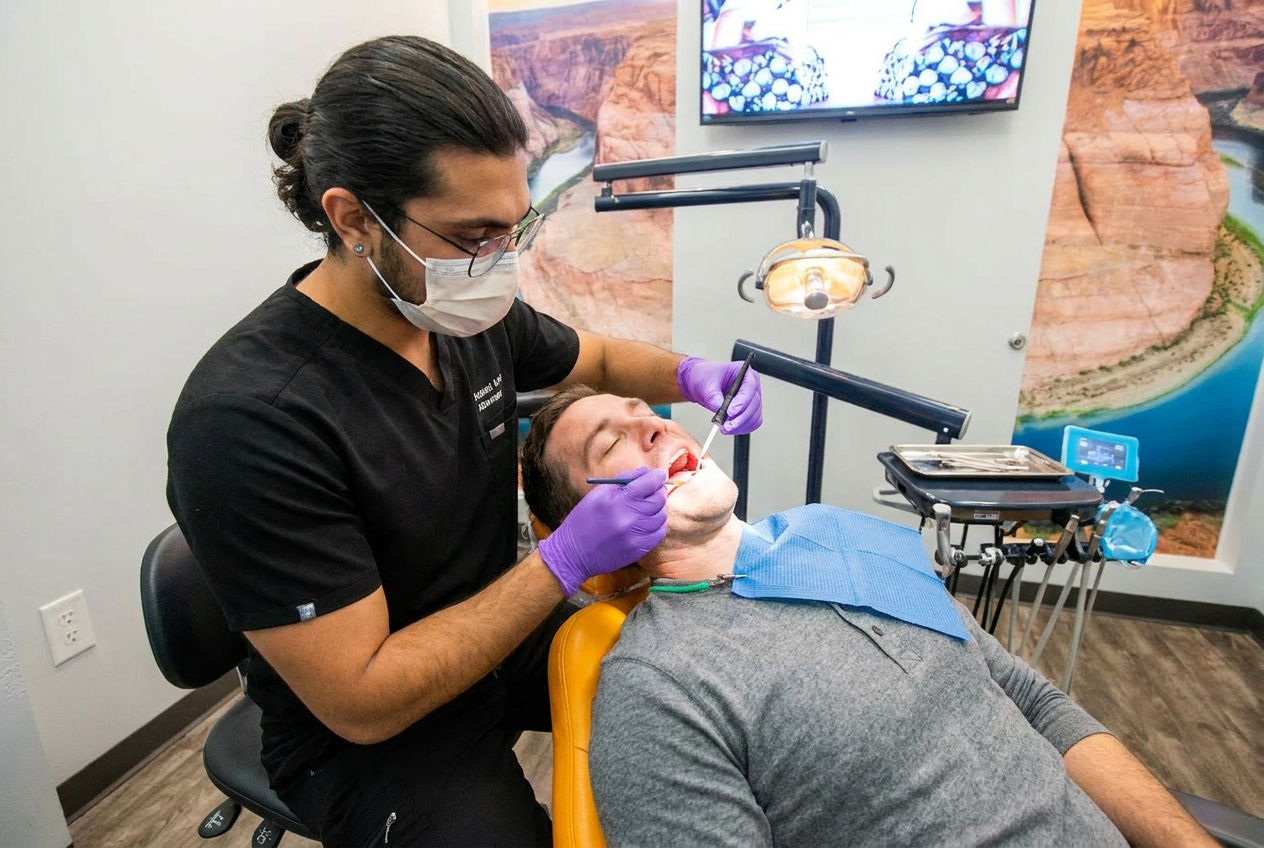 Dr. Karnik Shah performing a dental procedure on a male patient in the treatment chair at Comfydent Smiles in Bee Cave, TX.