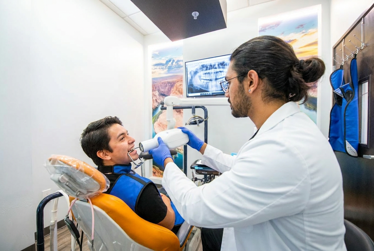 Dr. Karnik Shah taking a digital x-ray of a smiling young male patient wearing a lead apron at Comfydent Smiles in Bee Cave, TX.