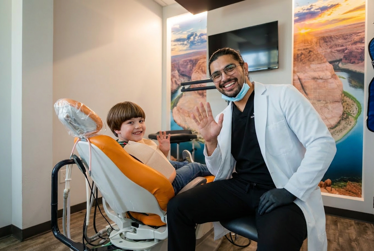 Dr. Karnik Shah waving and smiling alongside a young boy seated in the dental chair at Comfydent Smiles in Bee Cave, TX.