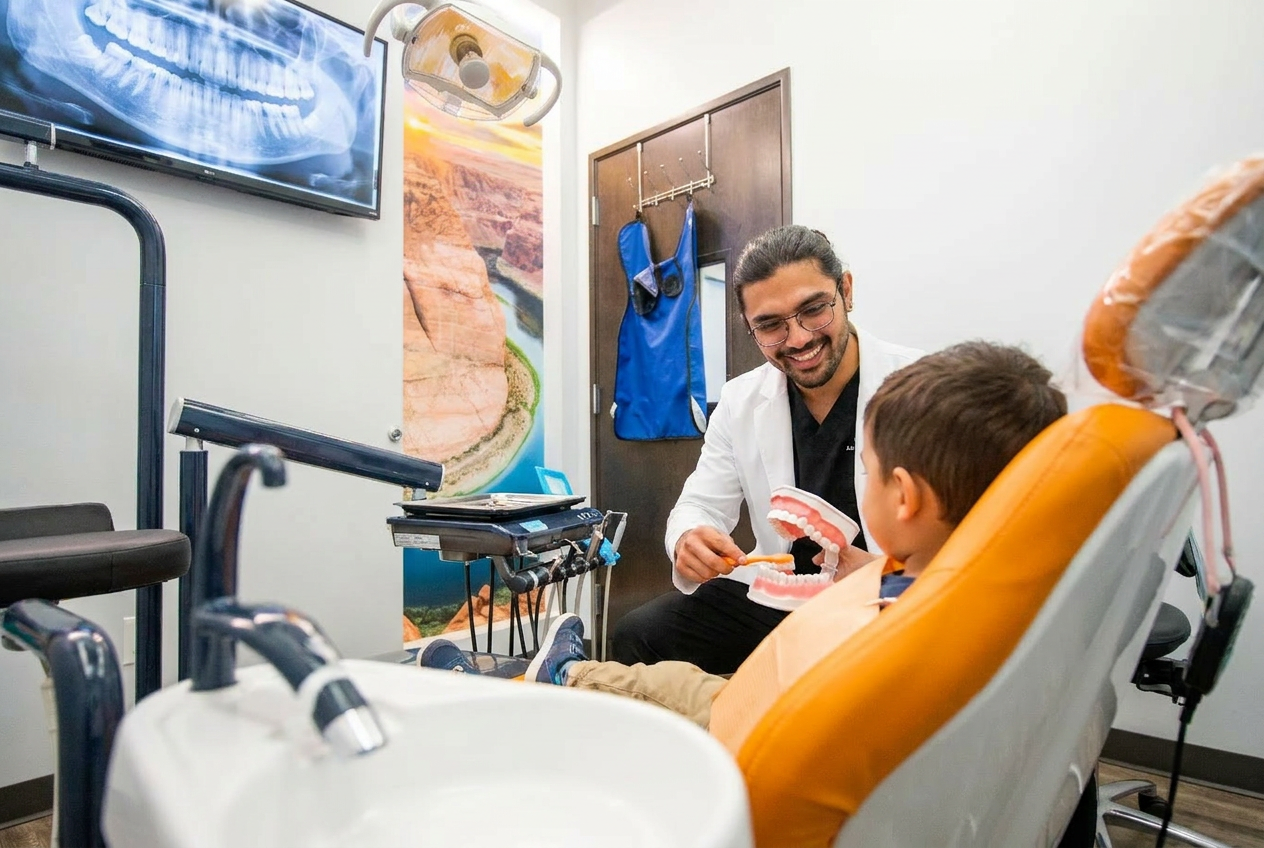 Dr. Karnik Shah showing a dental model to a young boy in the treatment chair during a children's dentistry visit at Comfydent Smiles in Bee Cave, TX.
