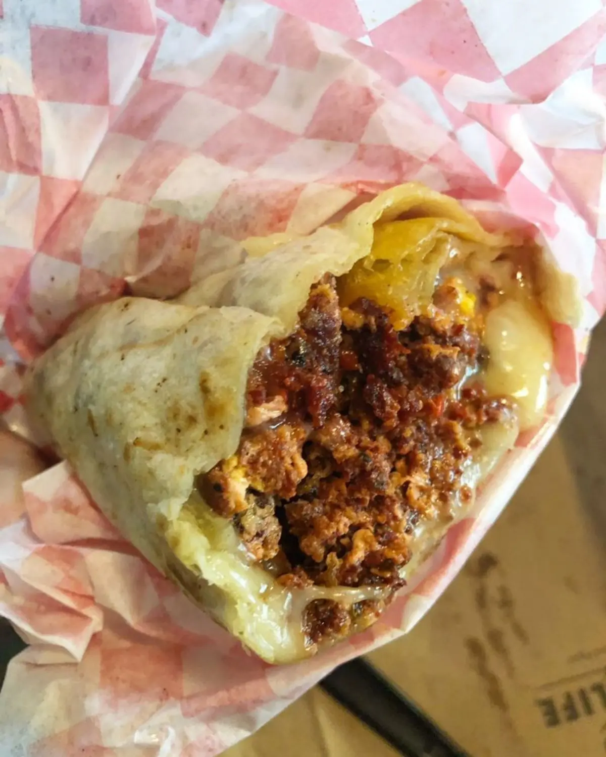 Spicy Mexican chorizo breakfast burrito wrapped in a warm flour tortilla, served at a local restaurant in Bakersfield, CA.