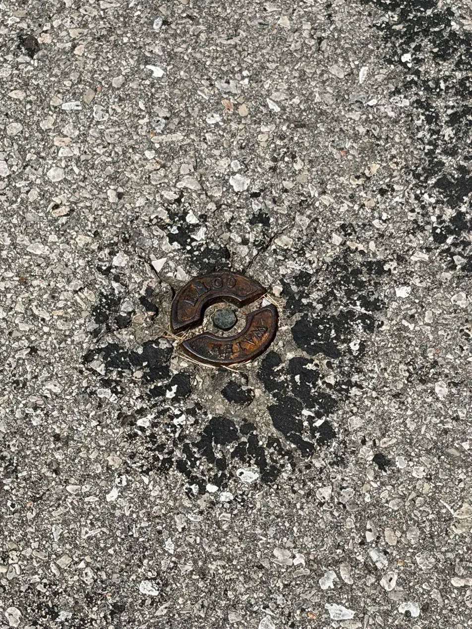 City water curb stop box cover in a residential driveway