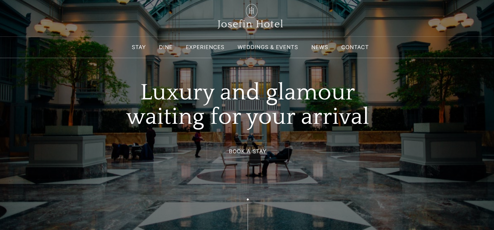 Spacious hotel lobby with marble floor, potted trees, and people sitting and walking.