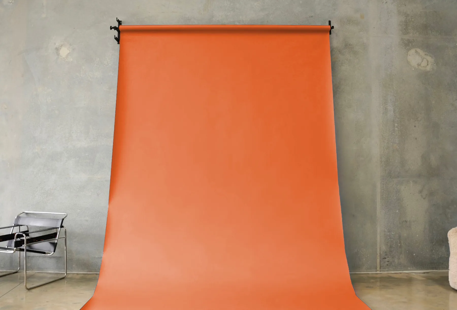 Orange seamless paper backdrop hanging in the BLANK studio