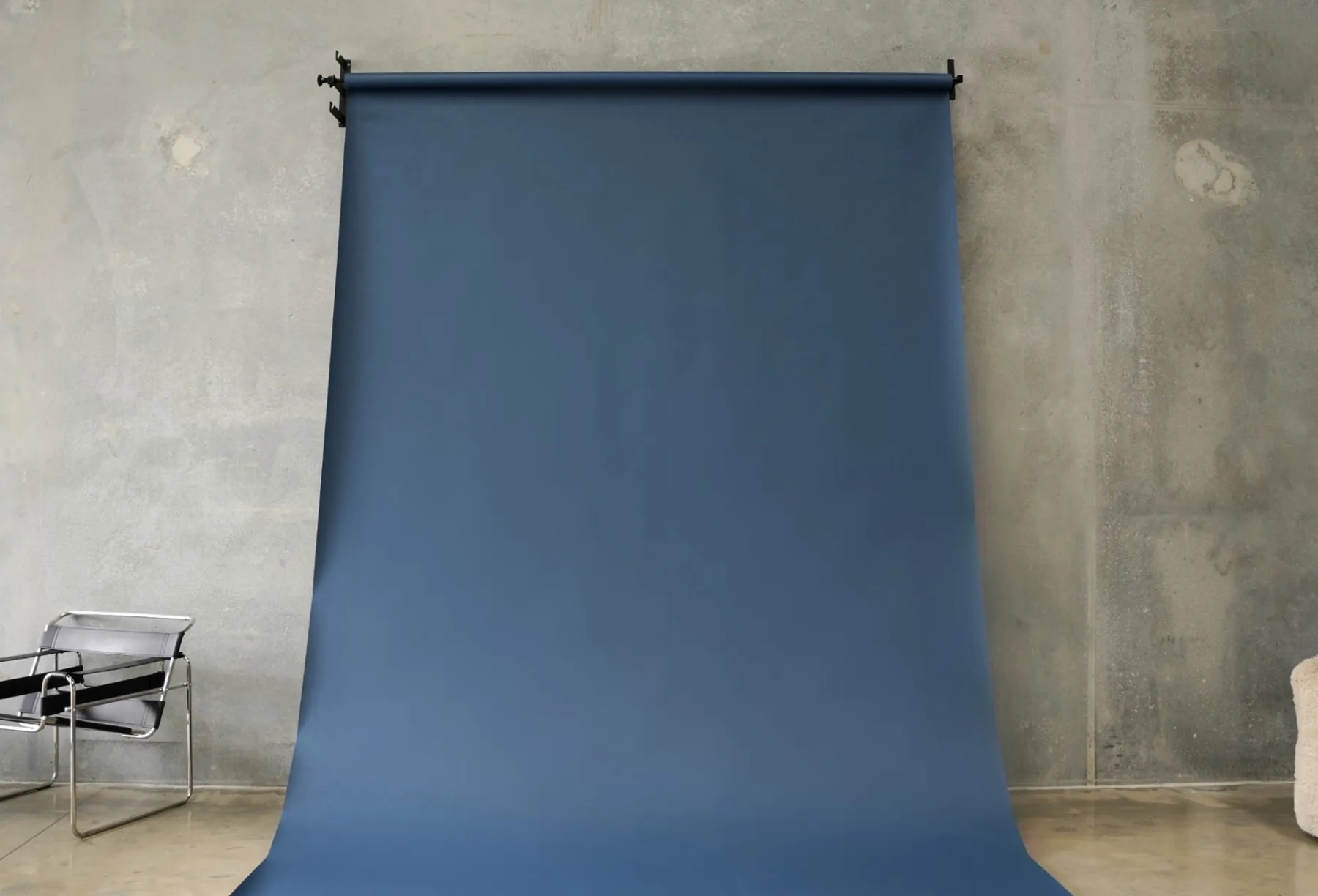 Dark blue seamless paper backdrop hanging in the BLANK studio