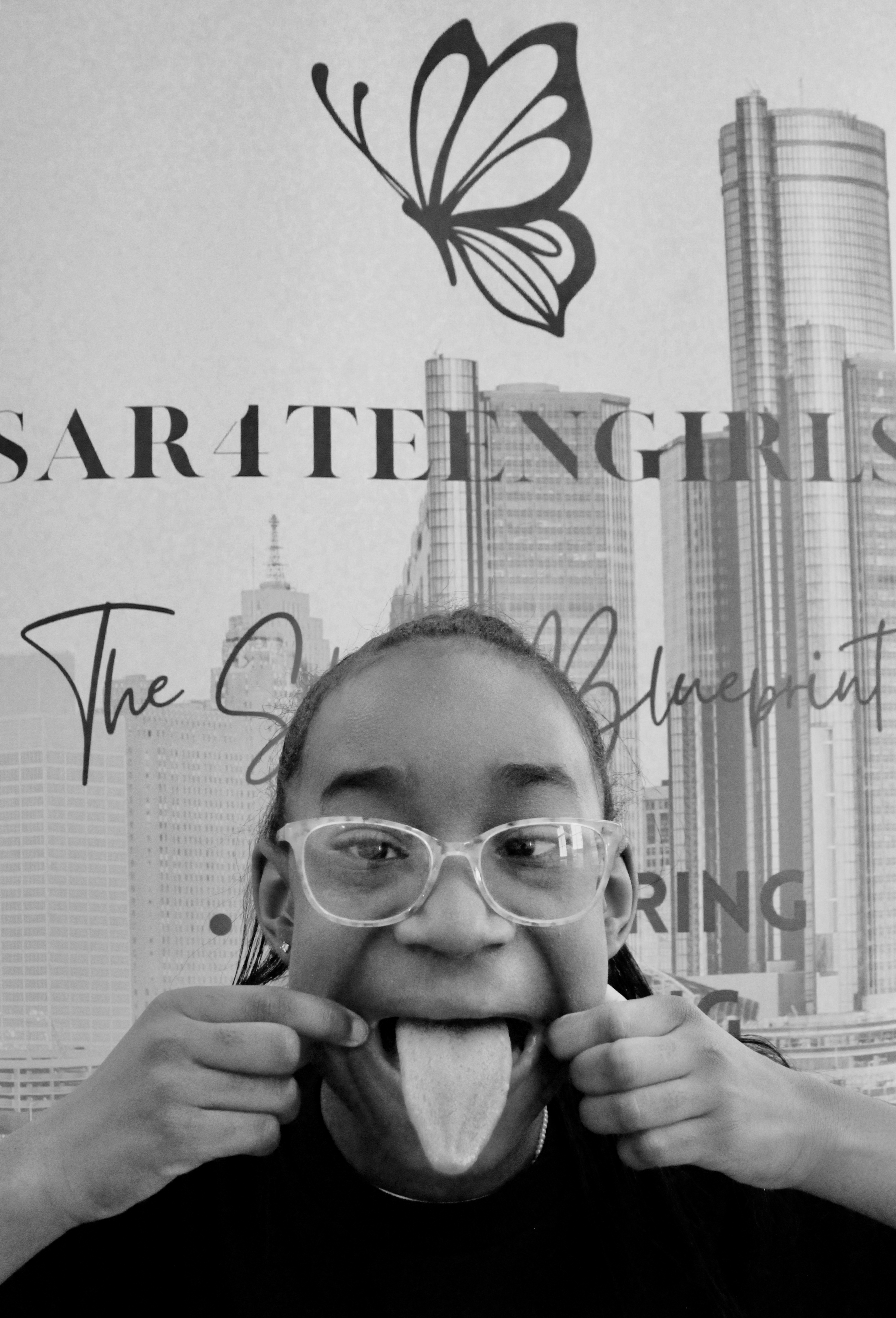 Ja’Dore lets out her sillies with her tongue in this black and white image.