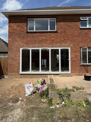 Newly fitted white bi-fold doors in a rear elevation