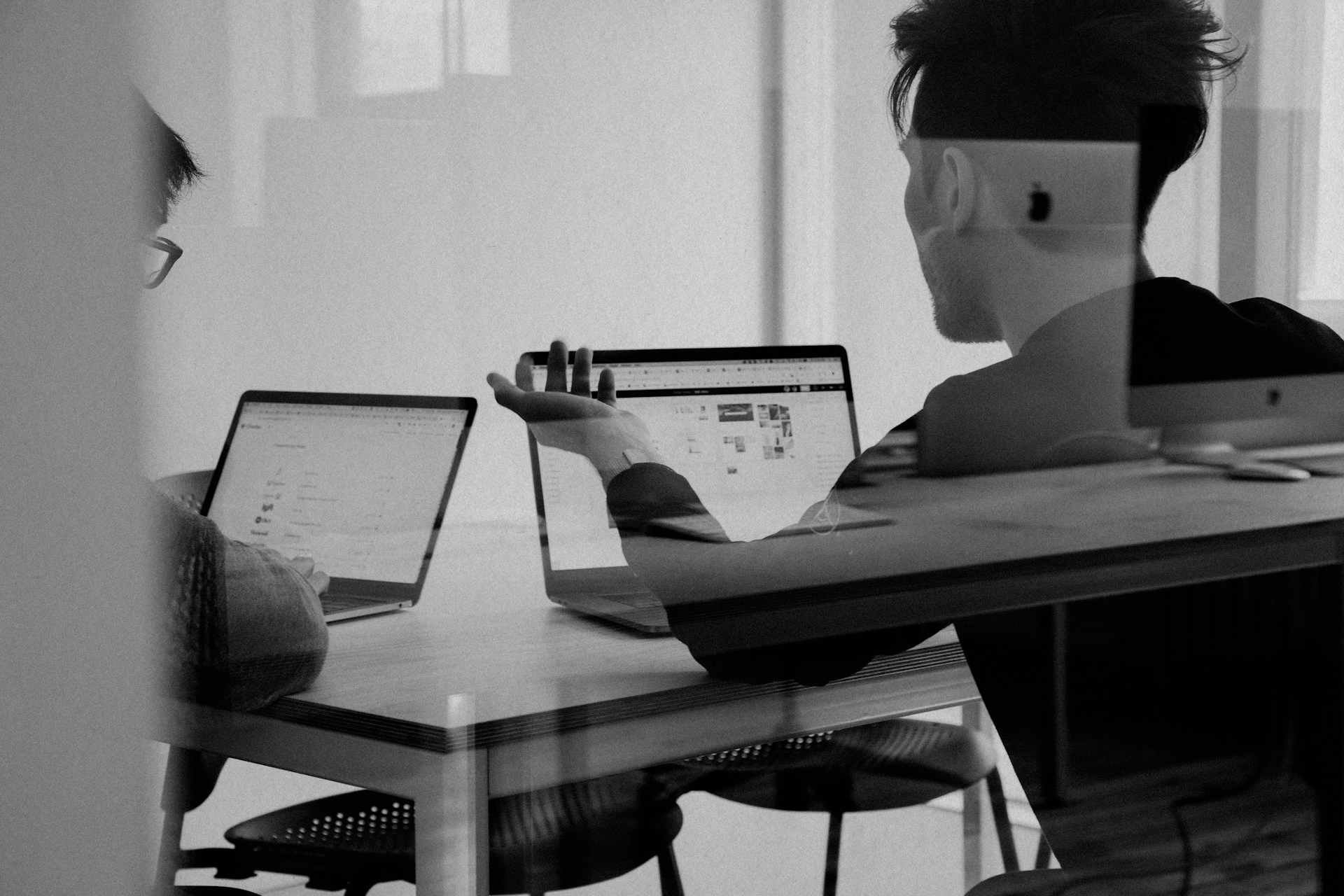 Over-the-shoulder view of a person using a MacBook for usability testing of the hotel booking prototype.