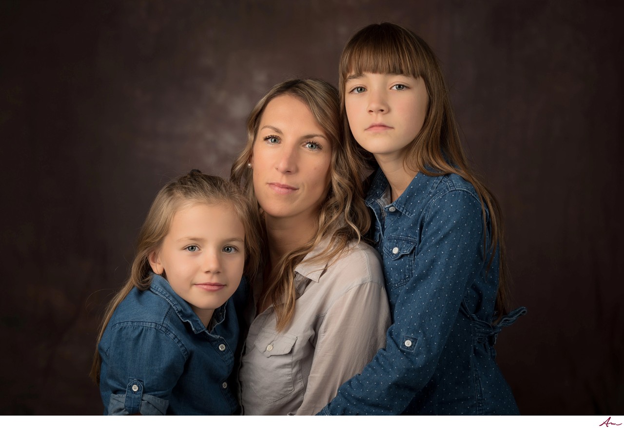 Mother with her two daughters in denim, quiet studio portrait on a dark backdrop, Halifax