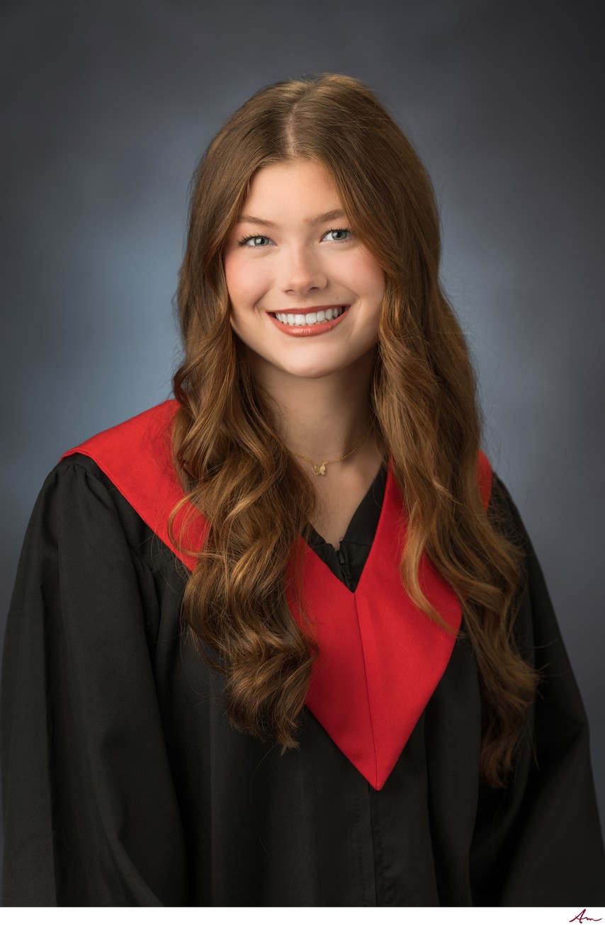Halifax West High senior in black graduation gown with red V-sash, formal studio grad portrait