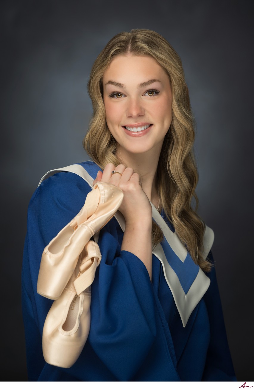 Charles P. Allen graduate in blue gown with worn ballet pointe shoes over her shoulder, Bedford