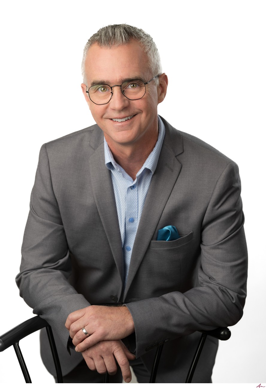 CTV News at 5 co-host Jayson Baxter seated in a grey suit with teal pocket square, Halifax
