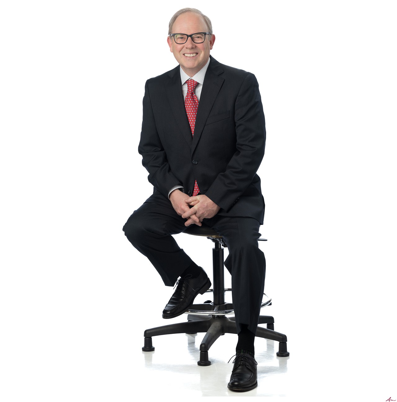 CTV News Atlantic chief anchor Todd Battis seated in a dark suit and red tie on white, Halifax