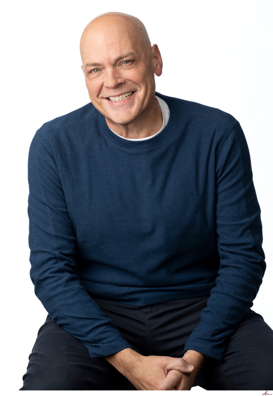 iHeartRadio host Peter Harrison laughing in a navy sweater, seated headshot on white, Halifax