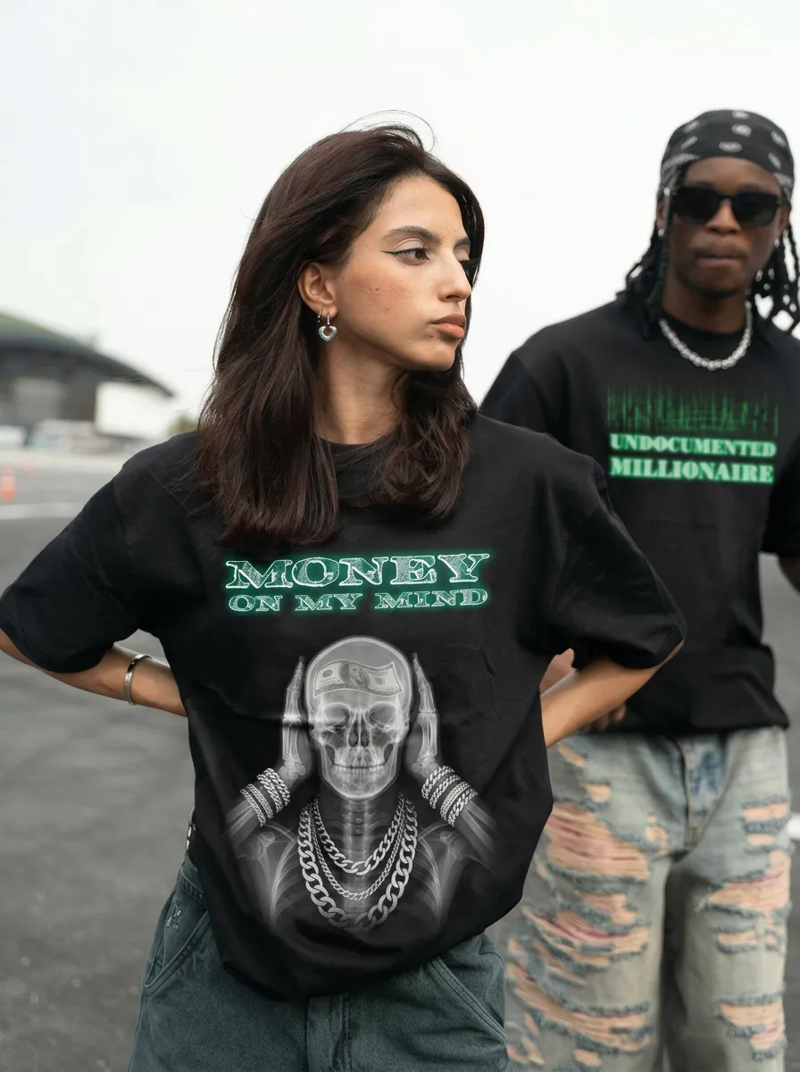 Woman wearing HVN NHTZ black shirt with skeleton and 'Money on my mind' text, man behind with 'Undocumented Millionaire' shirt.
