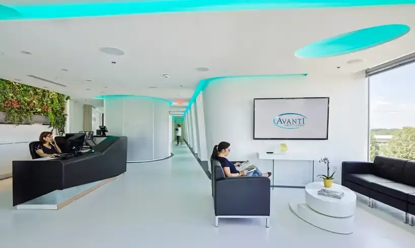 Modern clinic waiting area with a receptionist desk, seating, and a screen displaying Digital Clinic.