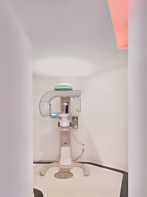 Dental panoramic X-ray machine in a clean, white dental office room.