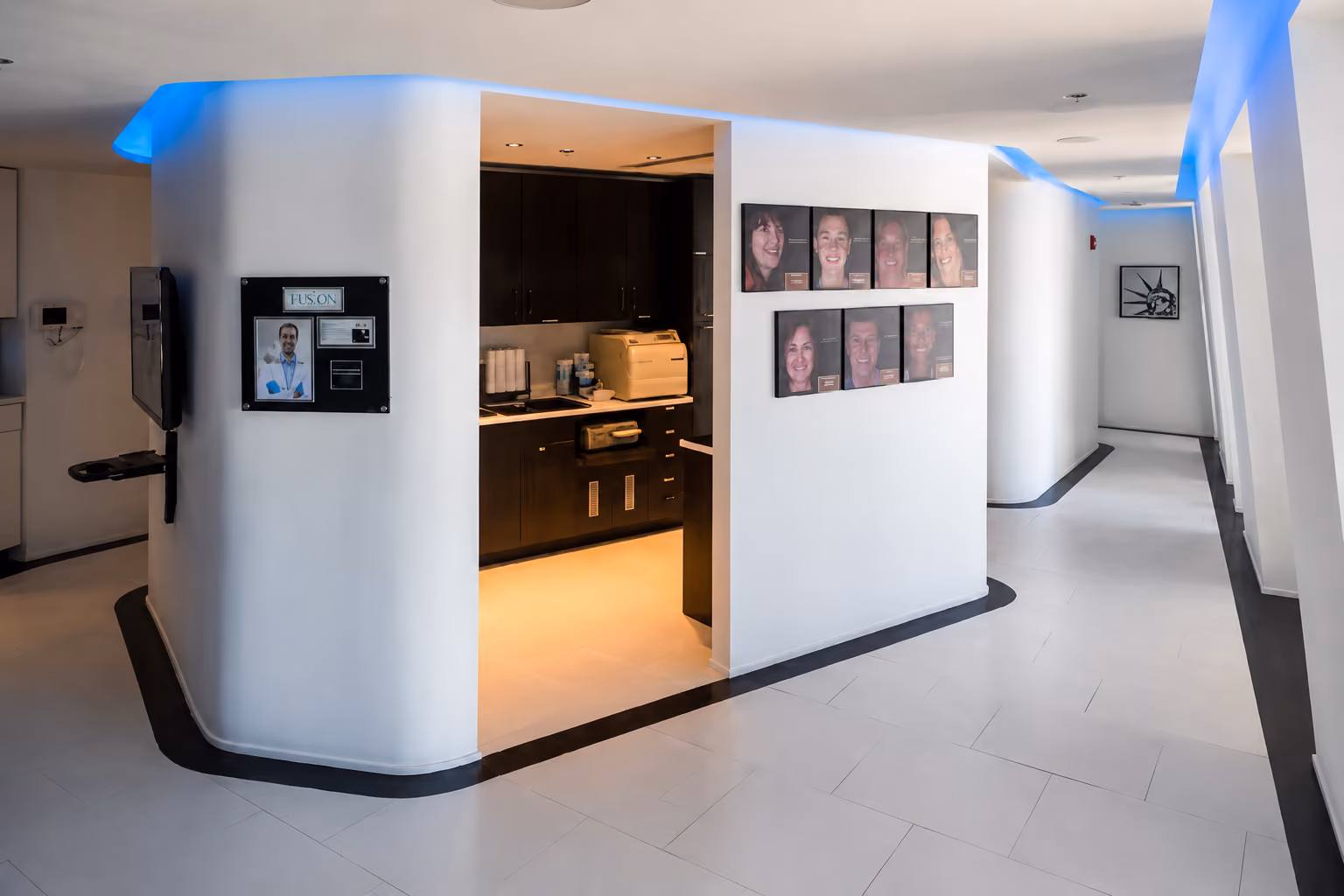 Modern hallway with white walls, black trim, blue LED lighting, and an open office area with a printer.