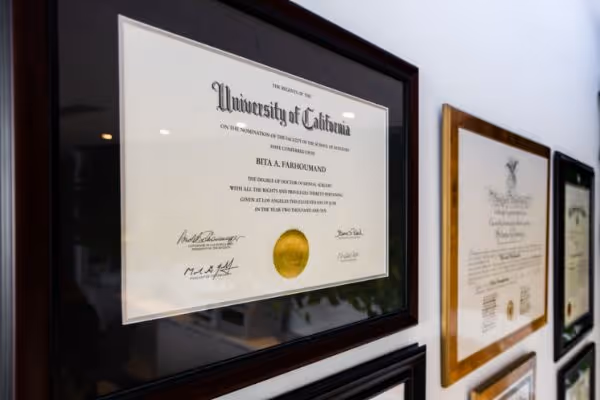 Framed University of California diploma hanging on a wall with other certificates.