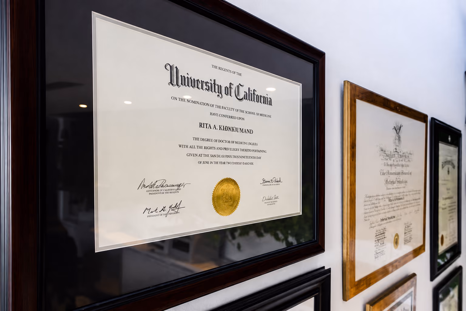 Framed University of California diploma hanging on a wall with other certificates.