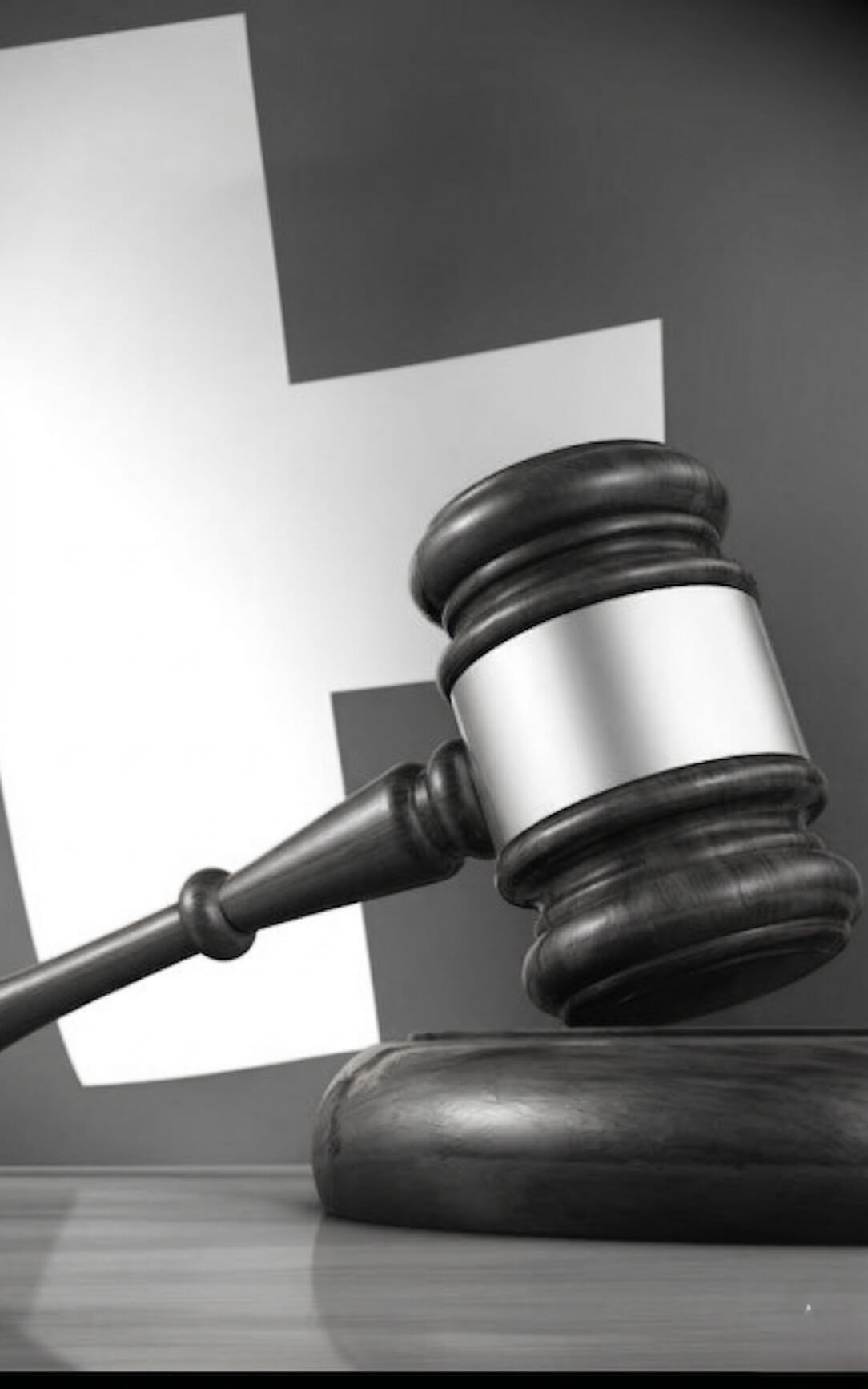 Close-up of a wooden judge's gavel with an empty metal plate on its head.