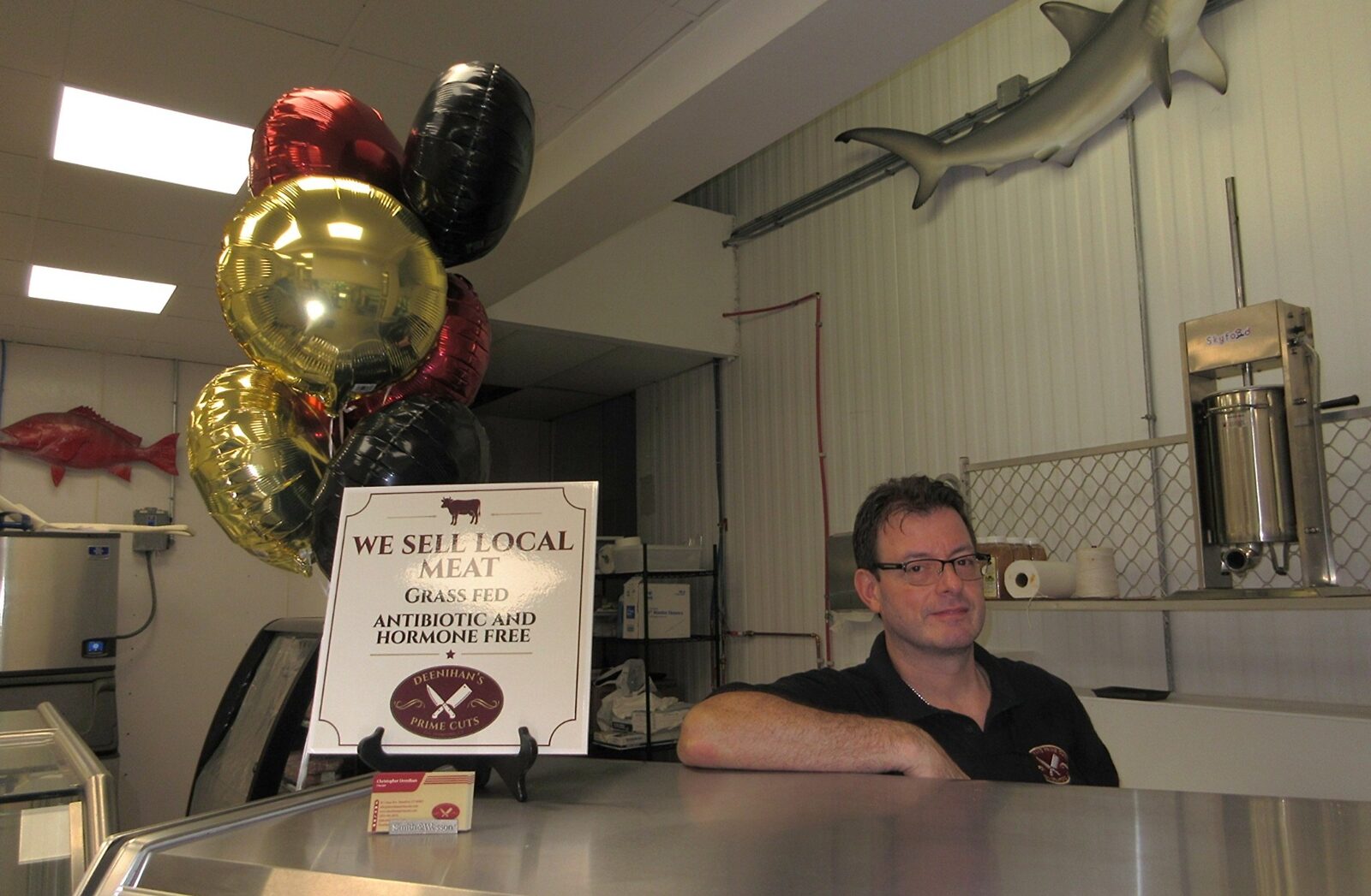 Chris Deenihan behind the meat counter at Deenihan's Prime Cuts, a family-owned butcher shop offering grass-fed, antibiotic- and hormone-free meat.