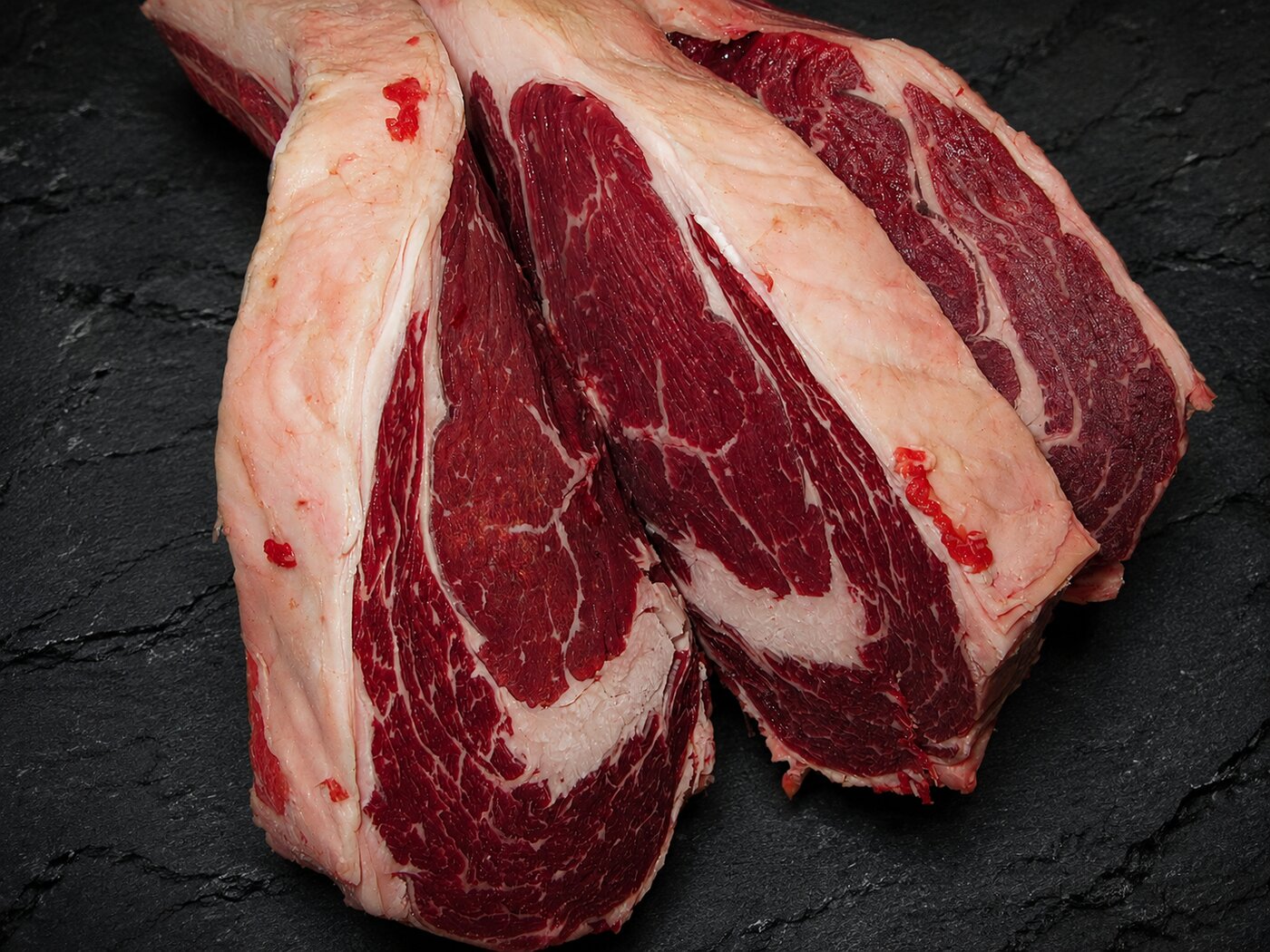 Two marbled beef cuts on dark slate at Deenihan's Prime Cuts.