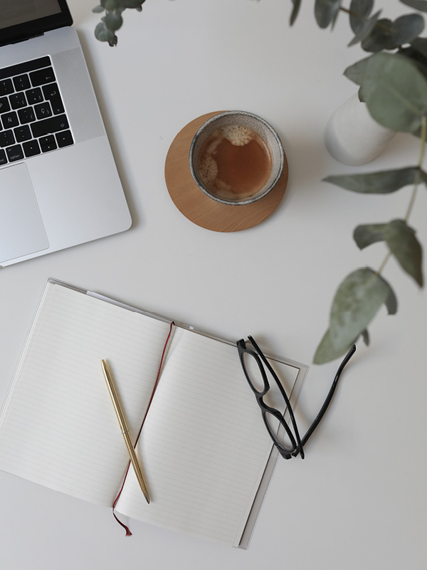 Image of a notebook + laptop + coffee