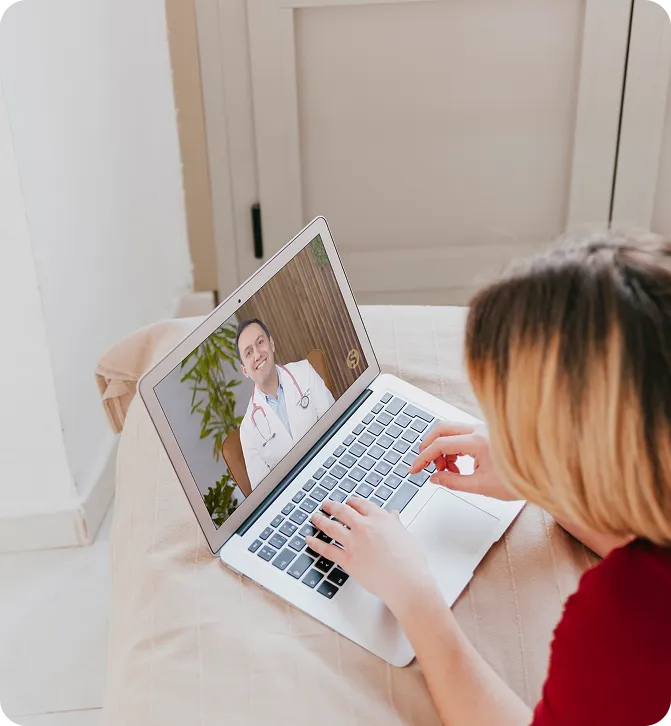 A patient interacting with a doctor on her computer for a video appointment