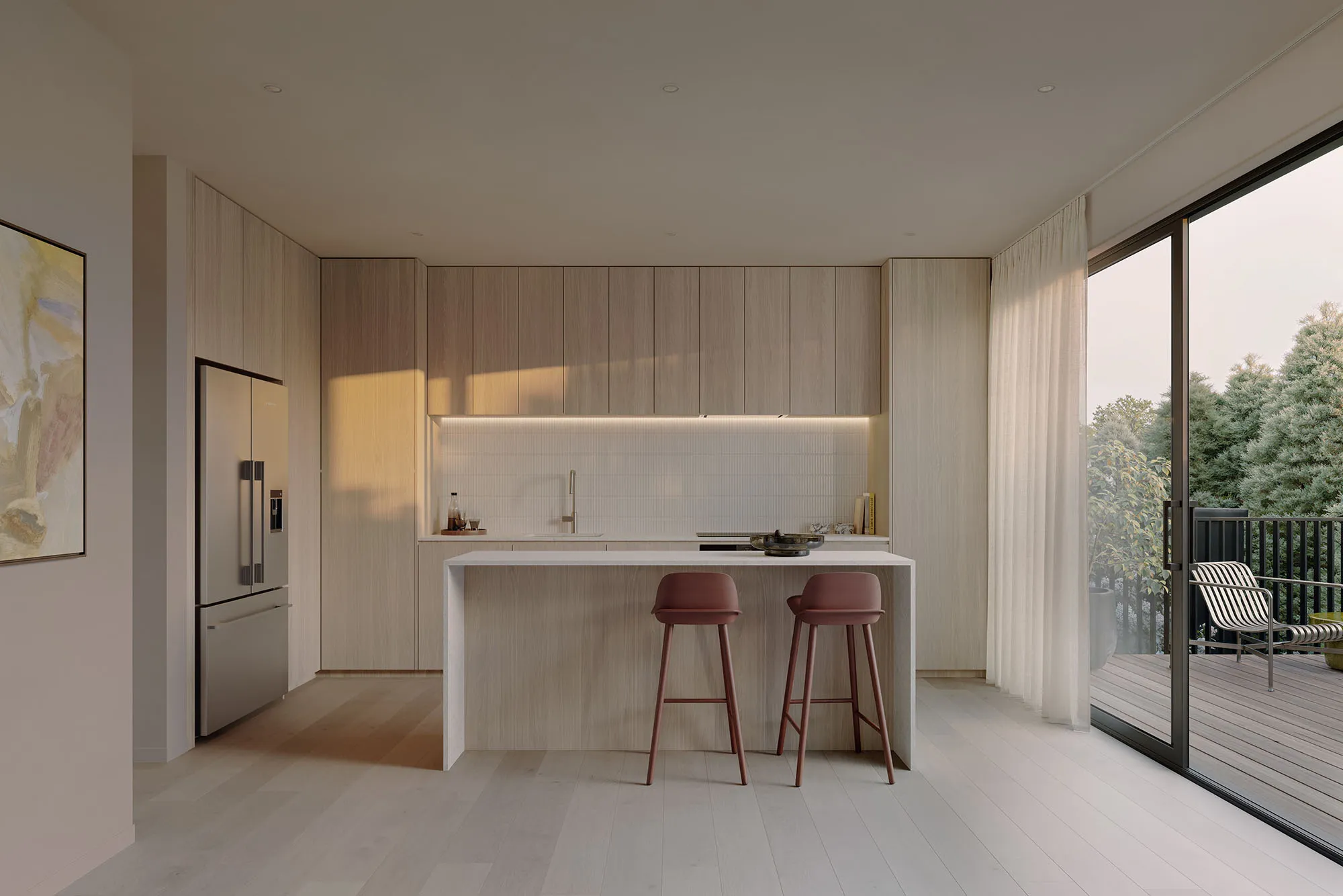 Light-toned Enclave kitchen with stone island, oak cabinetry and sliding doors to a private deck