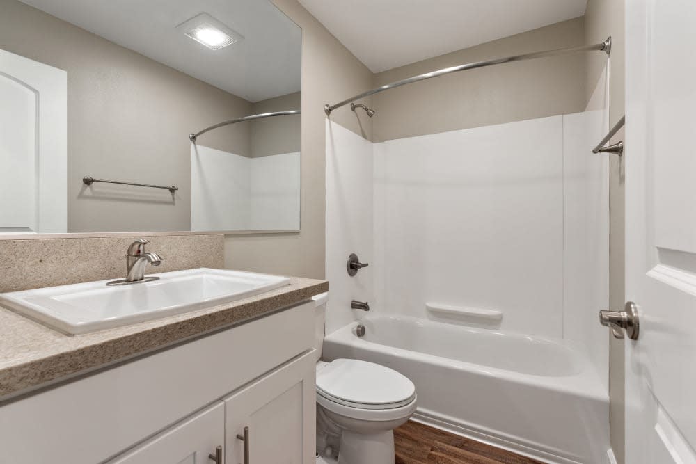 Bathroom with show tub combo and vanity with mirror and white cabinets