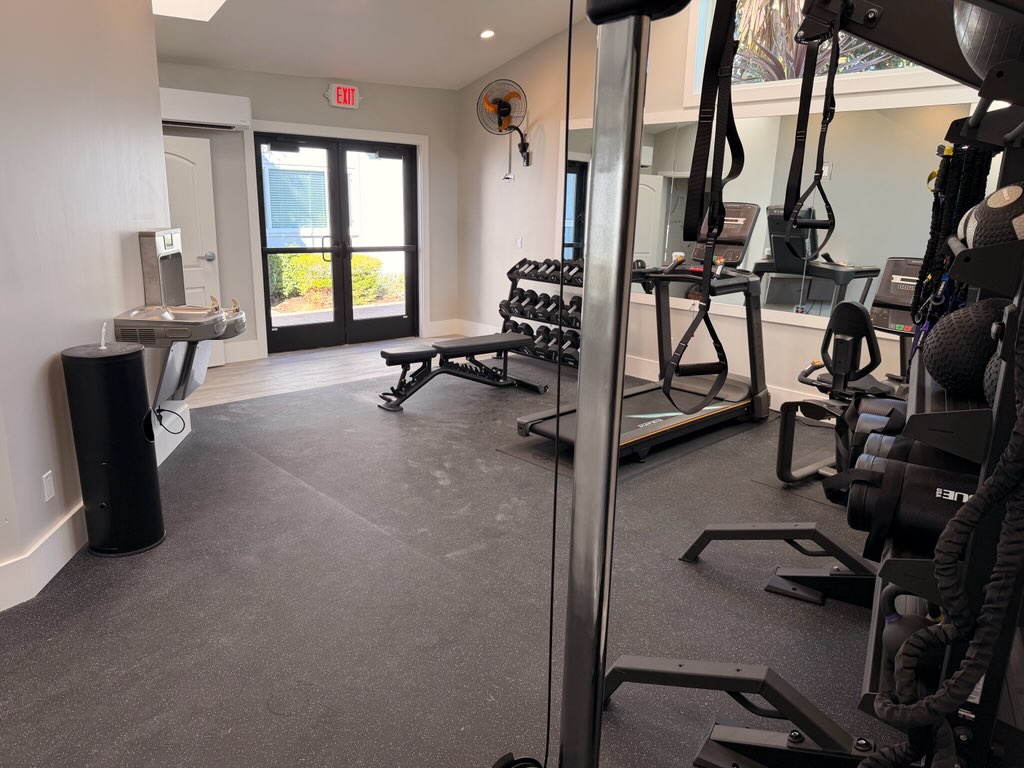 Inside fitness center with cardio machines and free weights