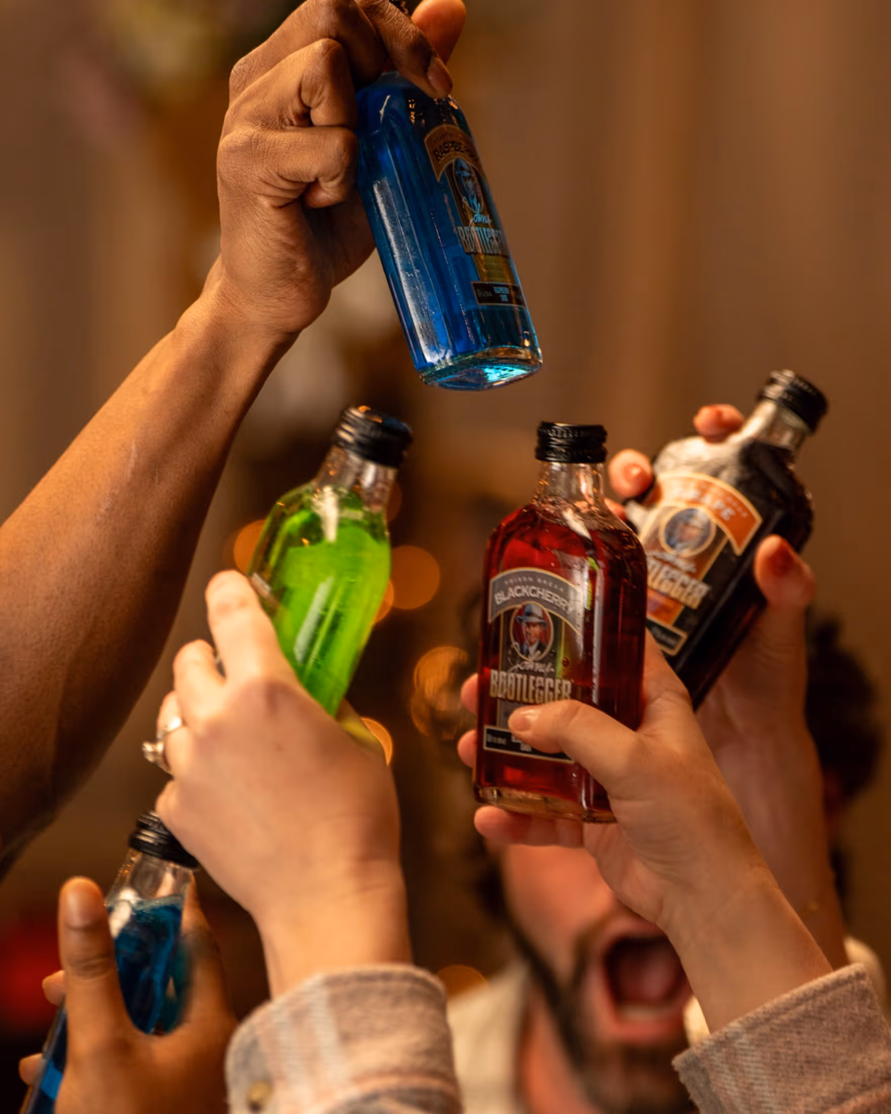 Party hands holding Johny Bootlegger bottles