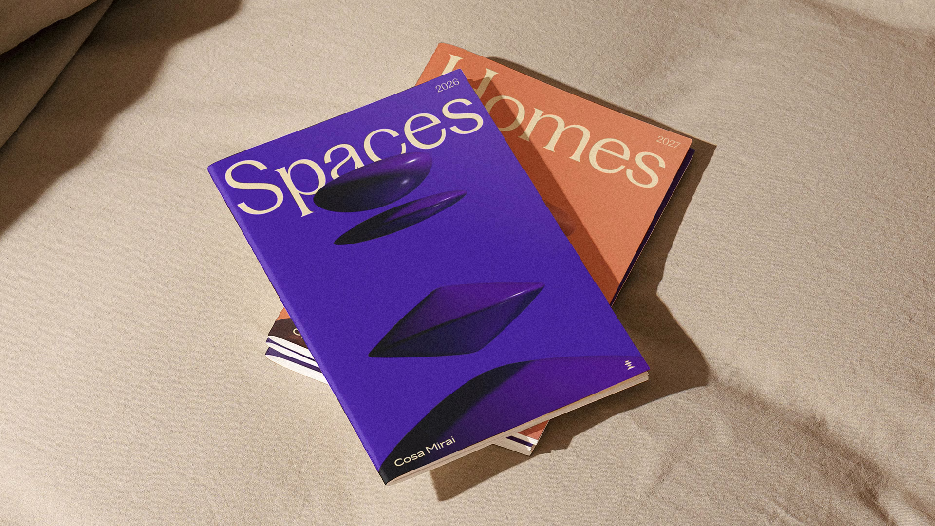 Purple and orange Cosa Mirai editorial magazines arranged on a sofa.