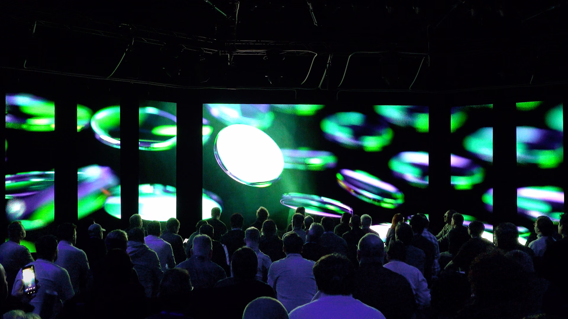Crowd gathered in front of an immersive green audiovisual installation