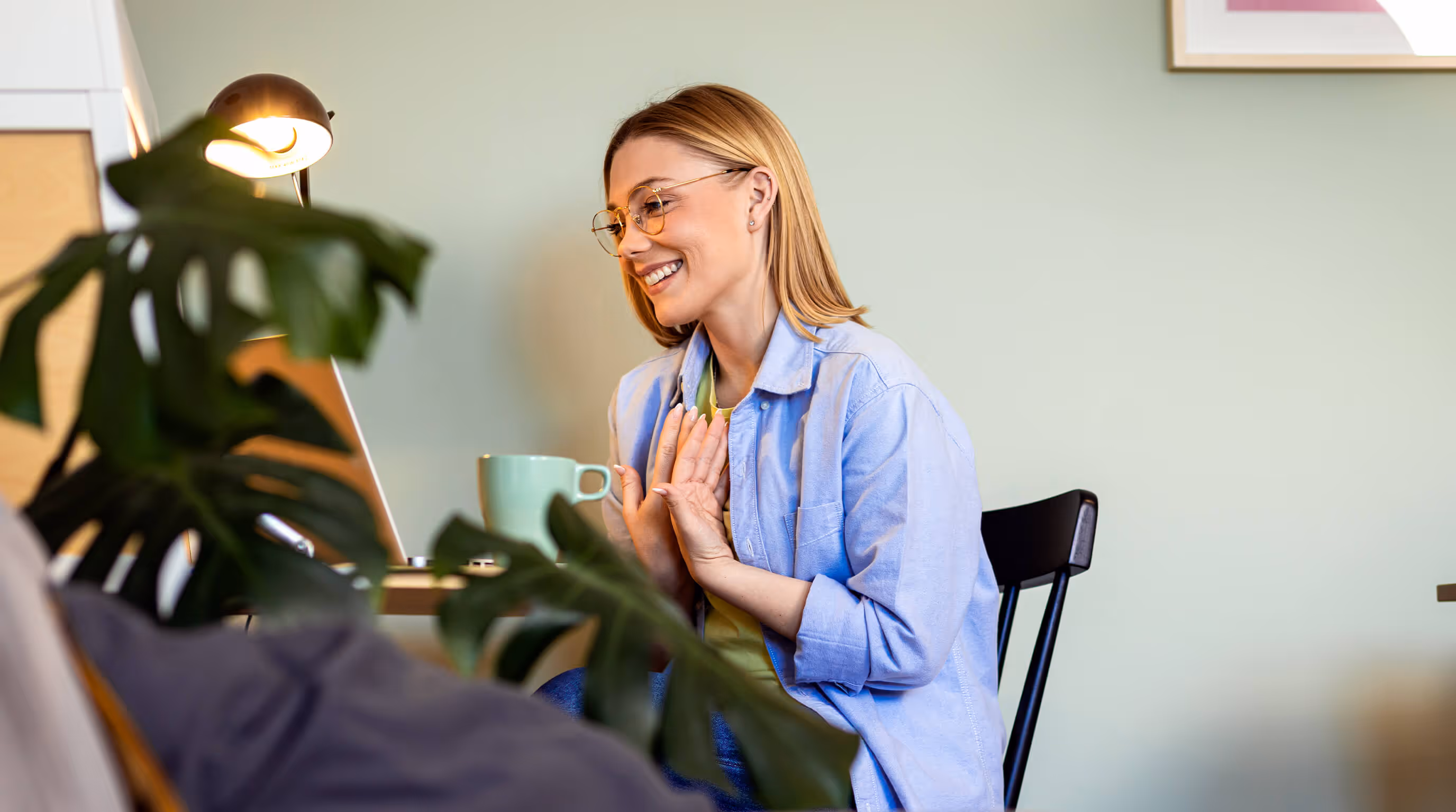Woman smiling during an online therapy session on a laptop at home