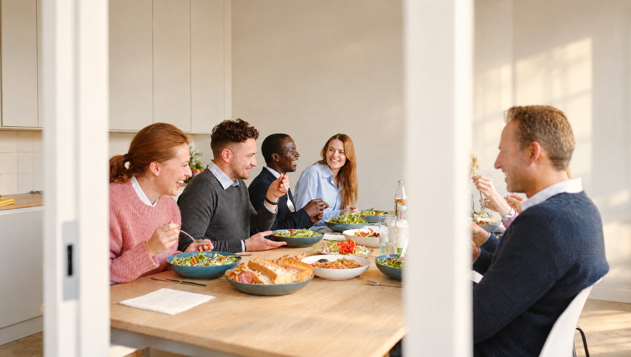 Ett team som äter lunch tillsammans och skrattar
